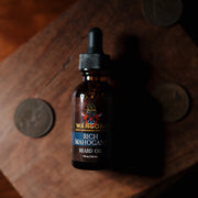 Warlord Rich Mahogany Beard Oil bottle on a dark-stained wooden block, surrounded by vintage coins—capturing a bold, masculine, and nostalgic aesthetic.