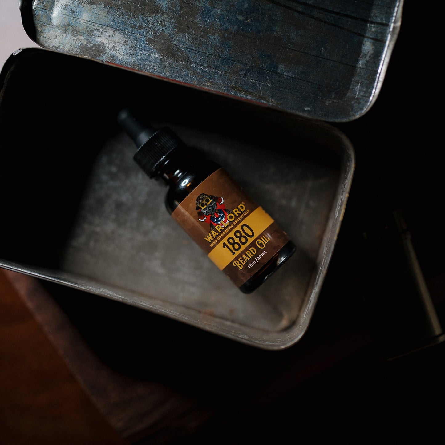 Warlord 1880 Beard Oil bottle inside a rugged vintage metal tin – masculine beard oil for men, classic men’s grooming essentials.