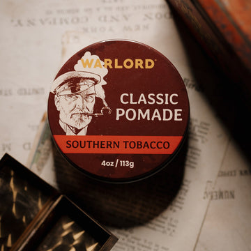 Warlord Southern Tobacco Classic Pomade tin on vintage paper with masculine grooming gear - Photograph