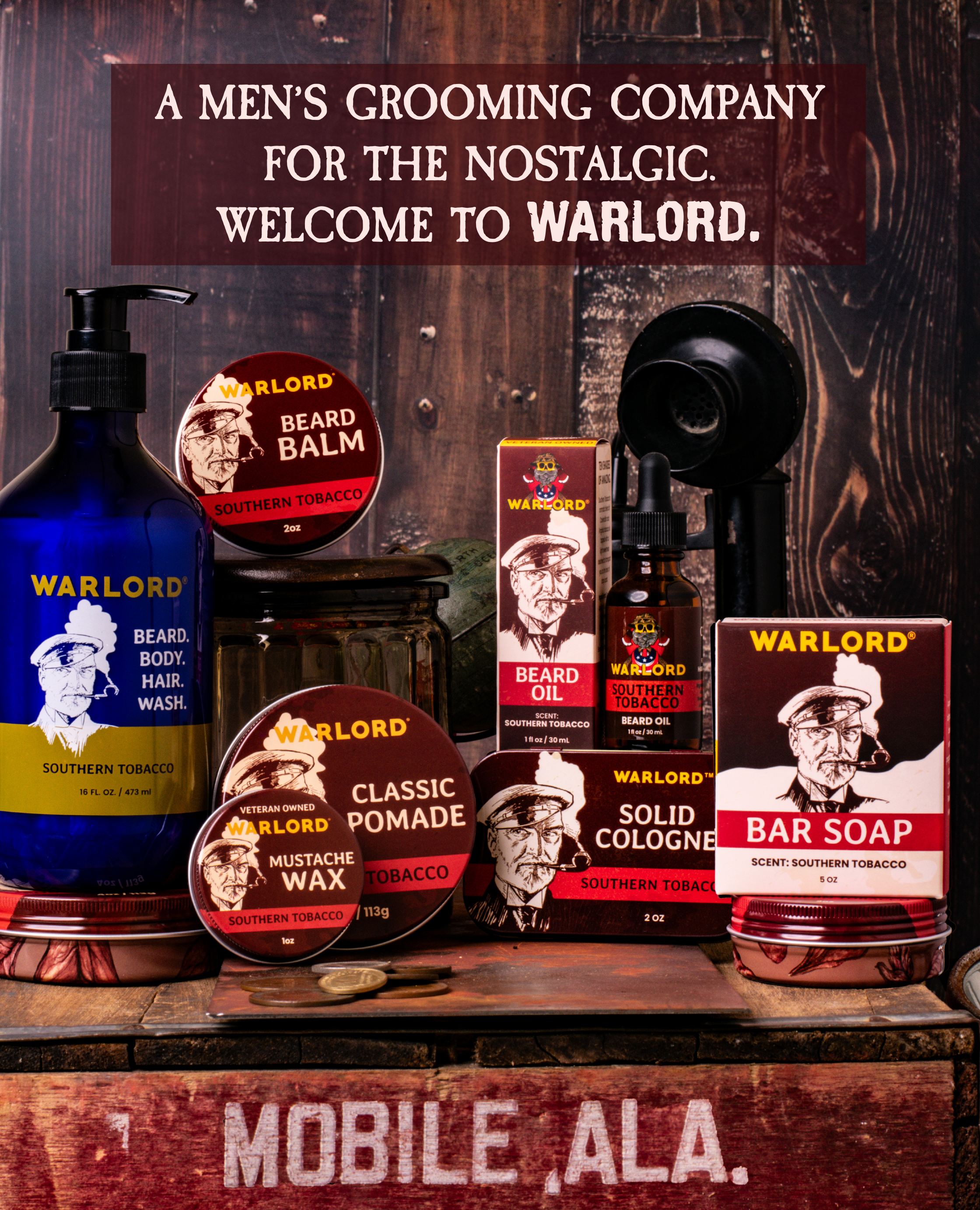 Warlord Men's Grooming Essentials display featuring a range of products such as beard oil, beard balm, bar soap, solid cologne, and beard wash all with a Southern Tobacco scent, showcased on a vintage rustic wooden background with candlestick telephone on top of an old crate that has in Mobile, Alabama. The vintage-style packaging emphasizes the nostalgic approach the company takes. A men's grooming company for the nostalgic. Welcome to Warlord..