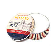 Open tin of Warlord Barbershop Mustache Wax showing wax texture and classic barbershop pole stripe design.